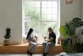 Young family, parents and little son sitting at the big window and showing a teddy bear to child Royalty Free Stock Photo