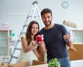 Young family with piggybank unpacking at new house with boxes