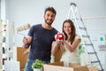 The young family with piggybank unpacking at new house with boxes