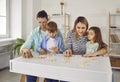 Parents playing with two kids in a puzzle in the living room at home. Royalty Free Stock Photo