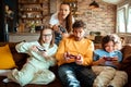 Young family playing video games together in the living room on a gaming console Royalty Free Stock Photo