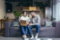 A young family, a pregnant woman and a man accidentally received someone else`s parcel. They opened the box, disappointed. Sittin Royalty Free Stock Photo