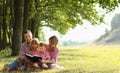 Young family reading the Bible in nature