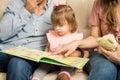 Young family reading a book together Royalty Free Stock Photo