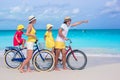 Young family riding bicycles on a tropical beach Royalty Free Stock Photo