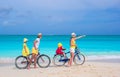 Young family riding bicycles on tropical beach Royalty Free Stock Photo