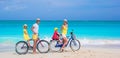 Young family riding bicycles on tropical beach Royalty Free Stock Photo