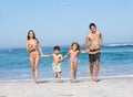 Young Family Running Along Beach on Holiday Royalty Free Stock Photo