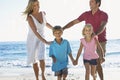 Young Family Running Along Sandy Beach On Holiday Royalty Free Stock Photo