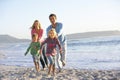 Young Family Running Along Sandy Beach On Holiday Royalty Free Stock Photo
