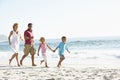 Young Family Running Along Sandy Beach On Holiday Royalty Free Stock Photo