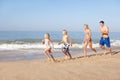 Young family running on beach Royalty Free Stock Photo