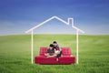 Young family seated on a sofa dreaming a home in the nature Royalty Free Stock Photo