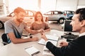 Young Family Are Signing A Contract To Buy A Car. Royalty Free Stock Photo