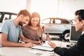 Young Family Are Signing A Contract To Buy A Car. Royalty Free Stock Photo