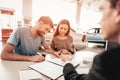 Young Family Are Signing A Contract To Buy A Car. Royalty Free Stock Photo