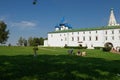 A young family sitting on the grass in front of the Suzdal Kremlin. Russia