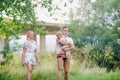 Young family with a small crying toddler boy in sunny summer nature.