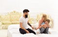 Young family spend time together on bed, luxury interior background. Mother and father cuddling with cute son. Parents Royalty Free Stock Photo