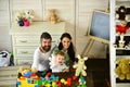 Young family spends time in playroom. Love and family game