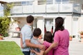 Young family standing in front of their dream home Royalty Free Stock Photo