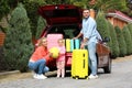 Young family with suitcases near car trunk Royalty Free Stock Photo