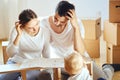 Family together at living room of new apartment assembling furniture, pile of moving boxes on background Royalty Free Stock Photo