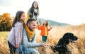 A young family with two small children and a dog on a walk in autumn nature. Royalty Free Stock Photo