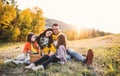 A young family with two small children having picnic in autumn nature at sunset. Royalty Free Stock Photo