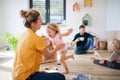 Young family with two small children indoors in bedroom playing.