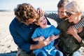 Young family with two small children sitting outdoors on beach, having fun. Royalty Free Stock Photo