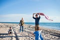 Young family with two small children walking outdoors on beach. Royalty Free Stock Photo