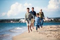 Young family with two small children walking outdoors on beach. Royalty Free Stock Photo