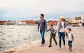 Young family with two small children walking outdoors on beach, holding hands. Royalty Free Stock Photo