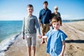 Young family with two small children walking outdoors on beach. Royalty Free Stock Photo