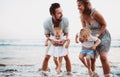 A young family with two toddler children having fun on beach on summer holiday. Royalty Free Stock Photo