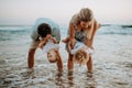 A young family with two toddler children having fun on beach on summer holiday. Royalty Free Stock Photo