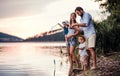 Young family with two toddler children outdoors by the river in summer, playing. Royalty Free Stock Photo