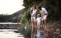 A young family with two toddler children outdoors by the river in summer. Royalty Free Stock Photo