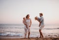 A young family with two toddler children having fun on beach on summer holiday. Royalty Free Stock Photo