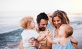 Young family with two toddler children walking on beach on summer holiday. Royalty Free Stock Photo
