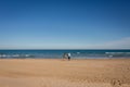 Young family walking in empty beach Gandia, Spain Royalty Free Stock Photo