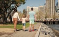 young family walking in park with son back view, parents