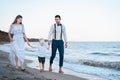 Young family walks on the beach with small child. Beautiful couple with son near the ocean Royalty Free Stock Photo