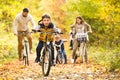 Young family in warm clothes cycling in autumn park