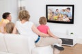 Young family watching tv together Royalty Free Stock Photo