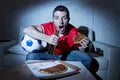 Young fan man watching football game on tv in team jersey suffering nervous and stress