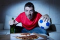 Young fan man watching football game on tv in team jersey suffering nervous and stress