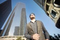 A young fancy man walking down the street among skyscrapers in a