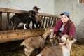 Young farm worker taking care of baby goats